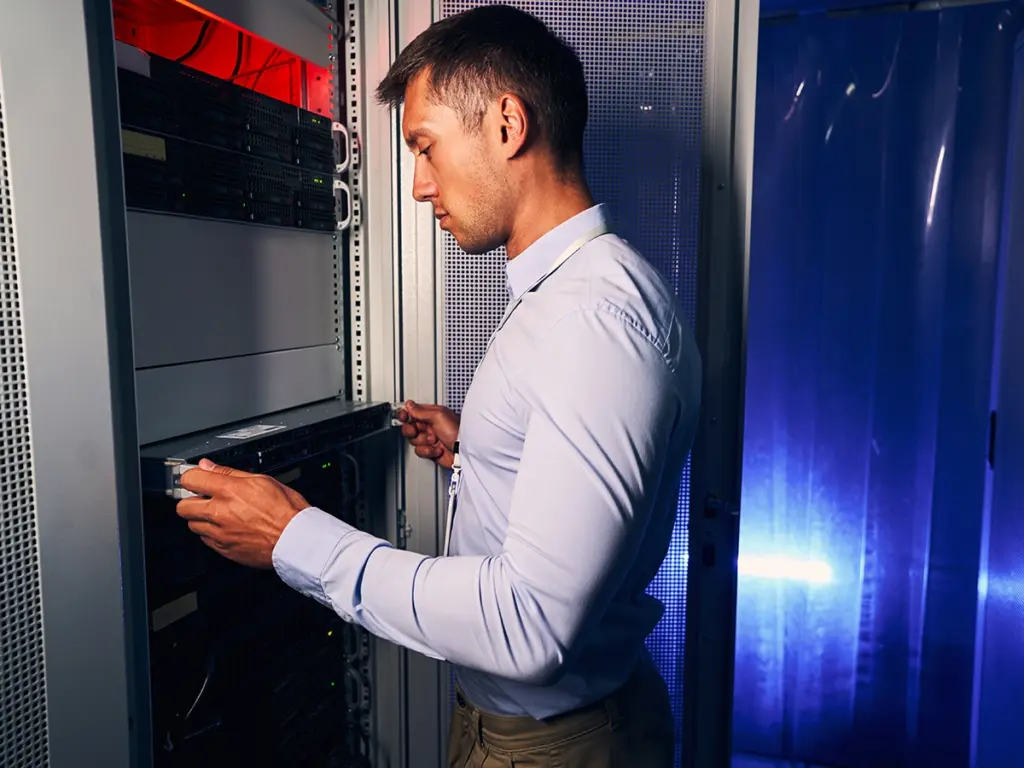 Person som arbetar vid ett serverrack i serverhallsmiljö