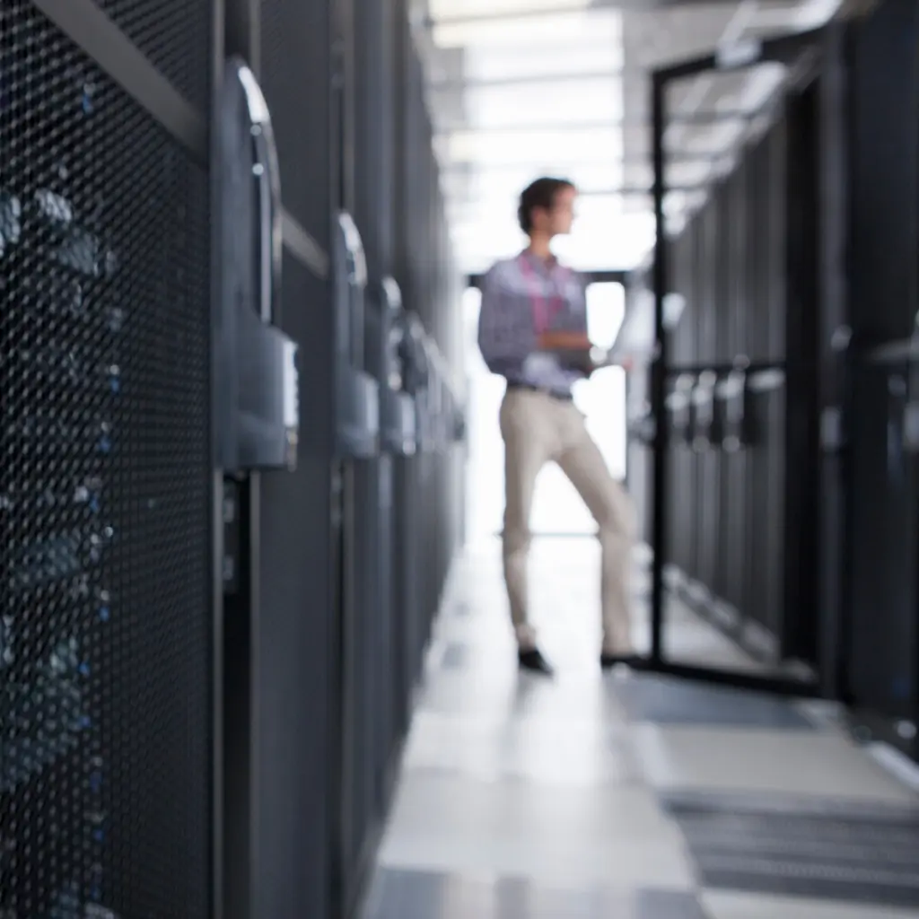 Person står i en serverhall mellan rader av serverrack.