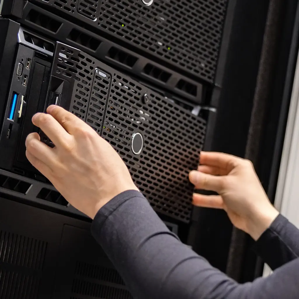 Händer monterar eller tar ut en serverenhet i ett serverrack.