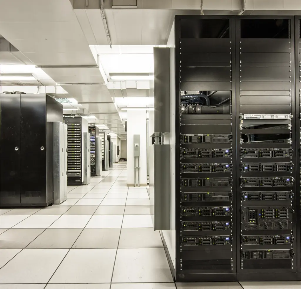 Serverhall med rader av serverrack och öppen serverutrustning i förgrunden.