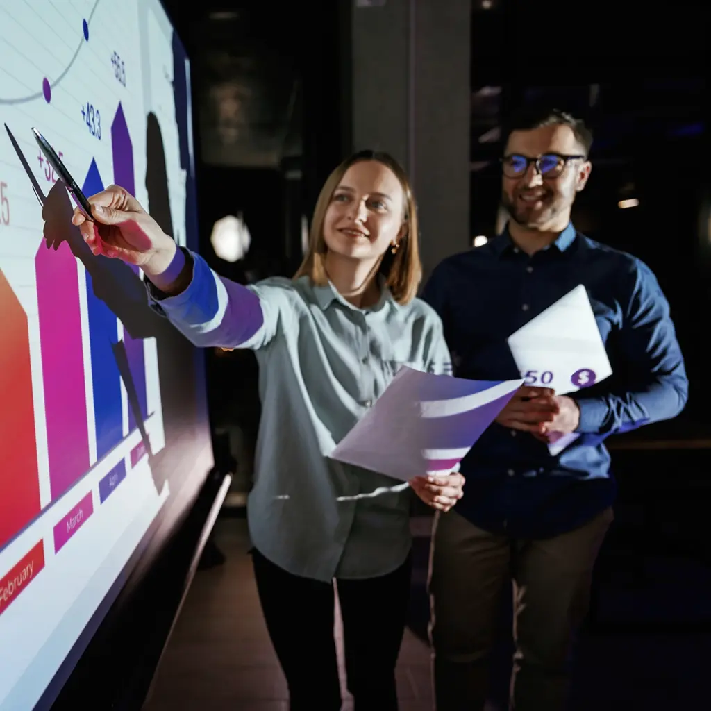 Personer analyserar diagram på en digital skärm