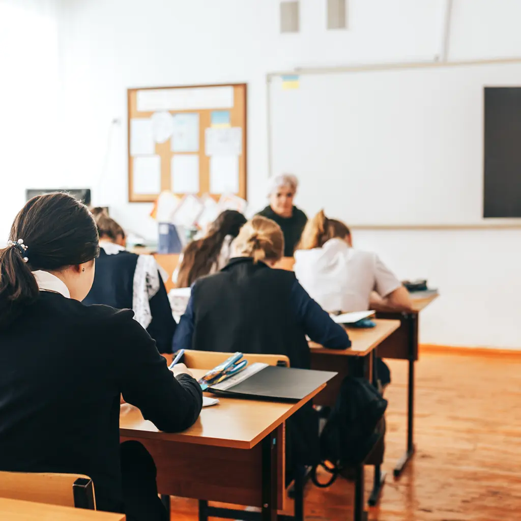 Personer sitter i klassrum och lyssnar på undervisning