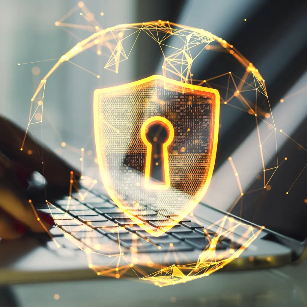 Lysande sköld med nyckelhål ovanför en bärbar dator som symbol för cybersäkerhet
