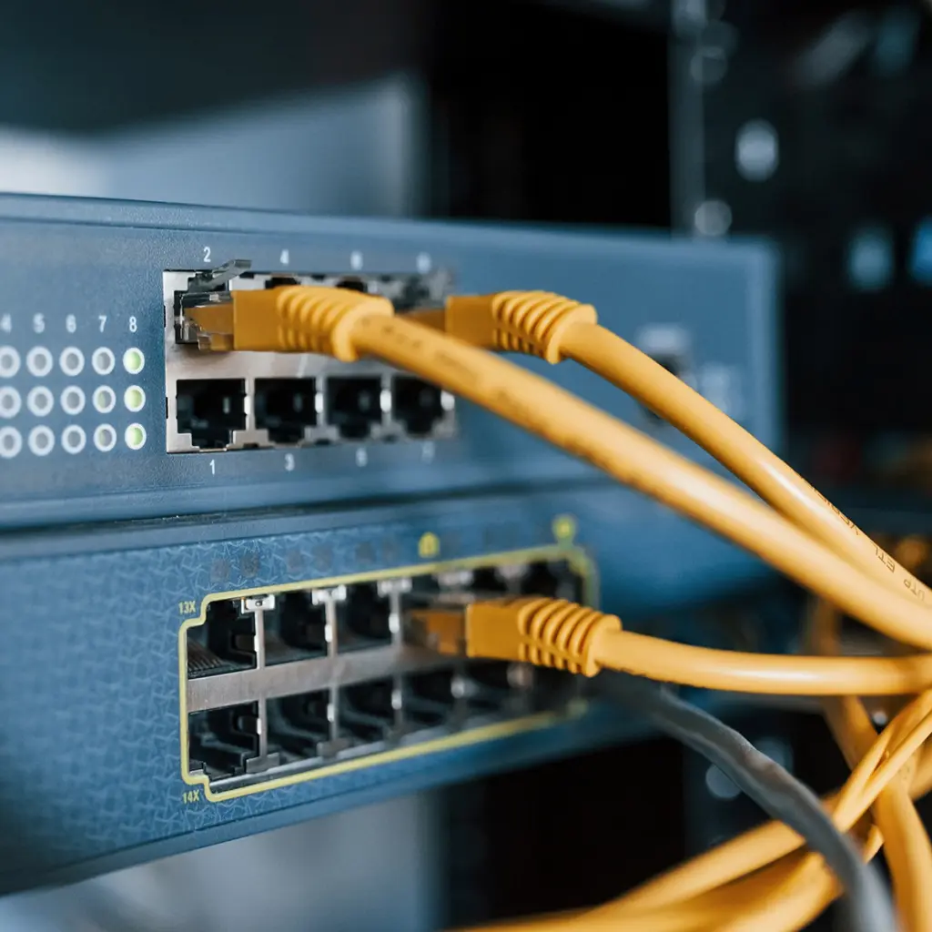 Gula Ethernet-kablar anslutna till portarna i en nätverksswitch